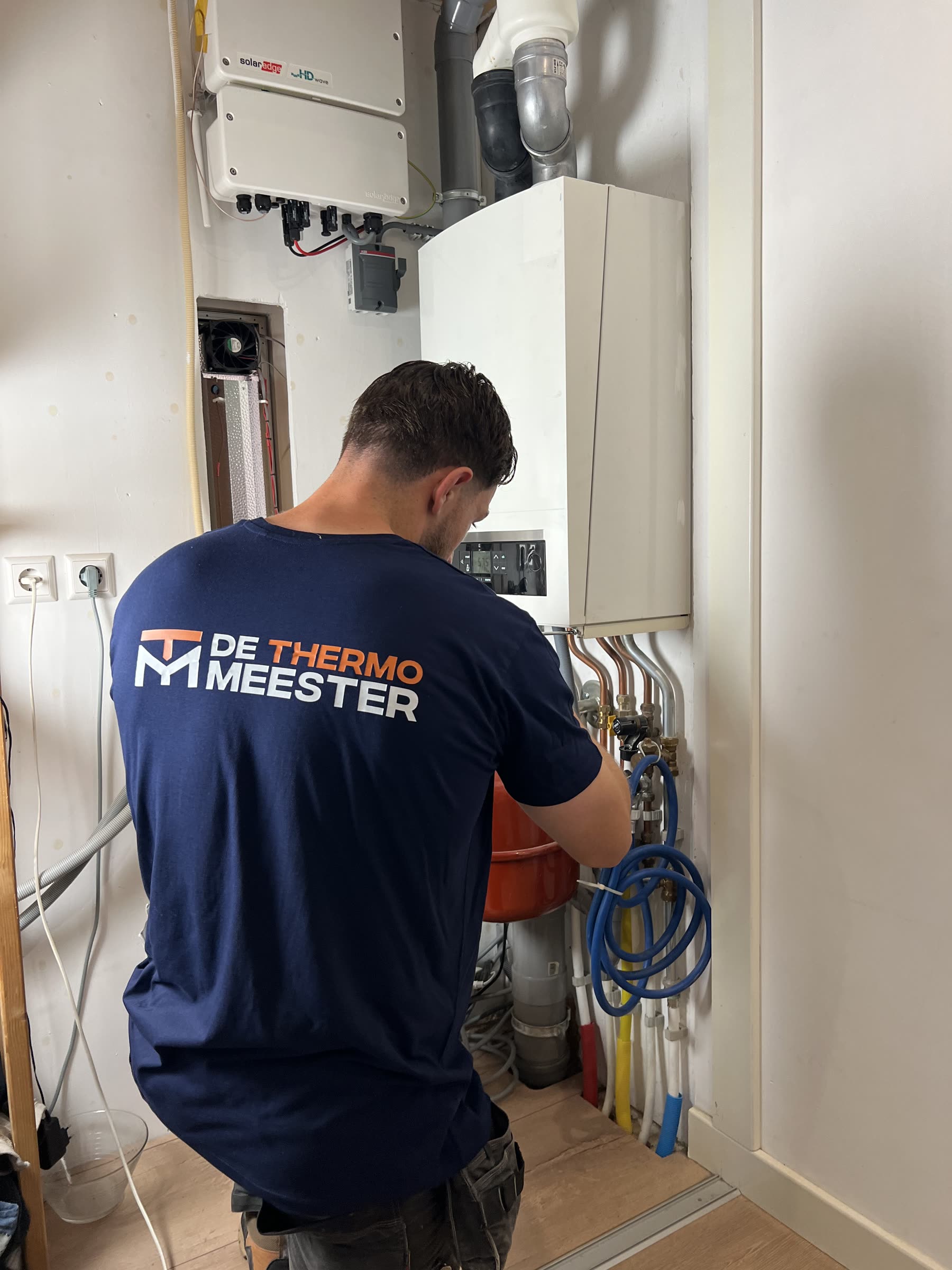 Monteur van De Thermomeester aan het werk bij een verwarmingsinstallatie